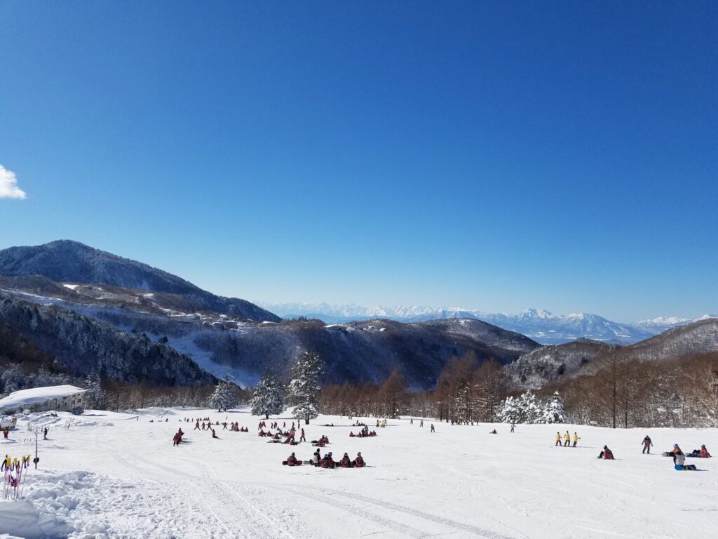 Tanne no mori Okojo in Japan - a group of people riding down a snow covered slope.