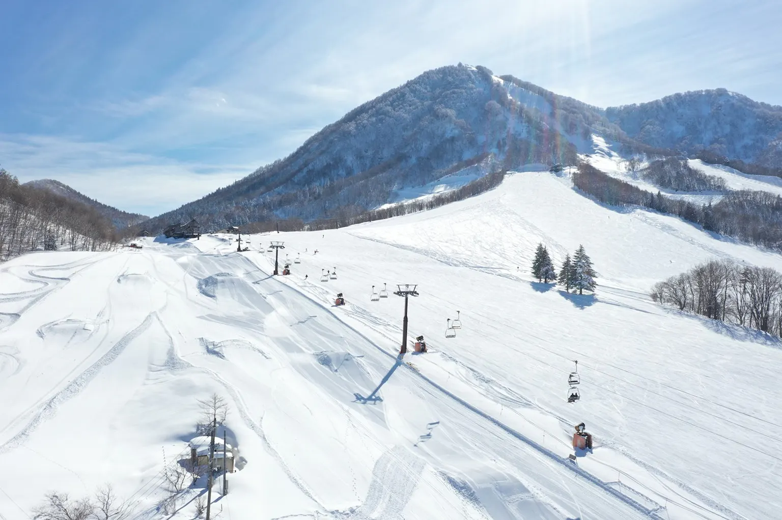 A winter scene at The Cupid of Romance ski resort in Nagano, Japan featuring stunning winter scenery, a charming chalet, and bustling winter sports activity.