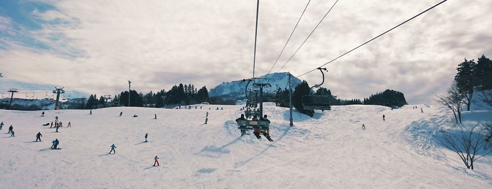 The Cupid of Romance in Japan - a group of people skiing down a snowy hill.