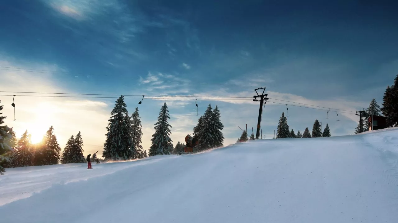 Image of a lively winter sports scene at the Ste-Croix - Les Rasses ski resort in Switzerland, showcasing vibrant ski slopes, a distant ski lift, amidst enticing winter scenery.