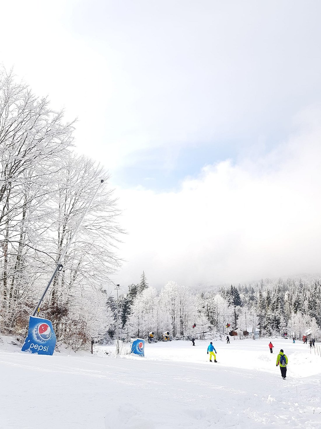 Winter sports enthusiasts enjoying a day at Superski Roata Cavnic in Romania, showcasing a picturesque winter scenery and impressive ski resort facilities.