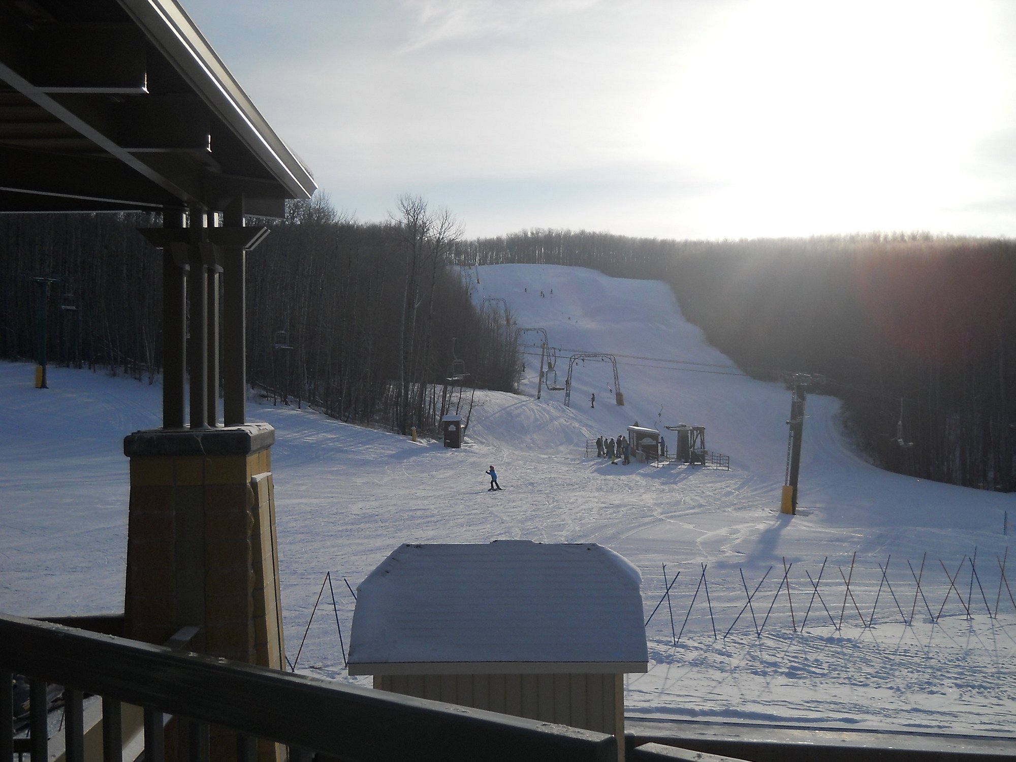 Winter scene at Kinosoo Ridge, Alberta, Canada, bustling with sports activities. The ski lift set against a backdrop of snow-covered slopes at a bustling ski resort.