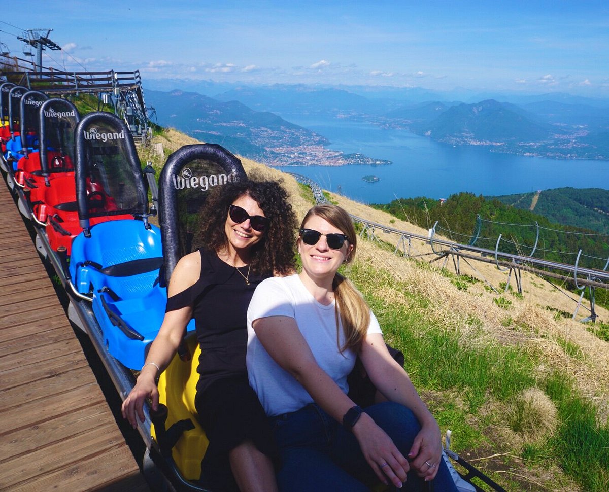 Mottarone in Italy - two women sitting on top of a mountain with a view of the lake.
