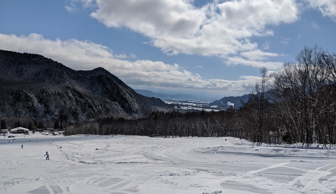 Stunning winter scene in Jiigatake, Japan featuring a ski resort nestled among snowy mountains, frequented by winter sports enthusiasts.