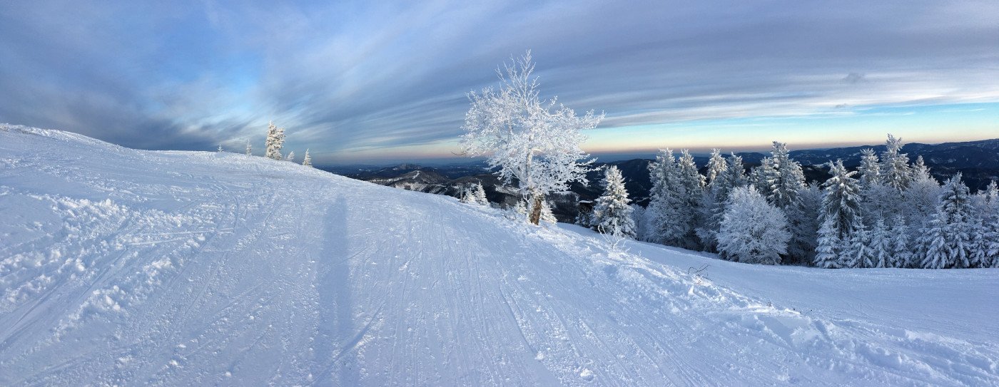 A lively winter sports scene at Unterberg, Austria with a cozy chalet amidst stunning winter landscape of Wiener Alpen, encased in snow.