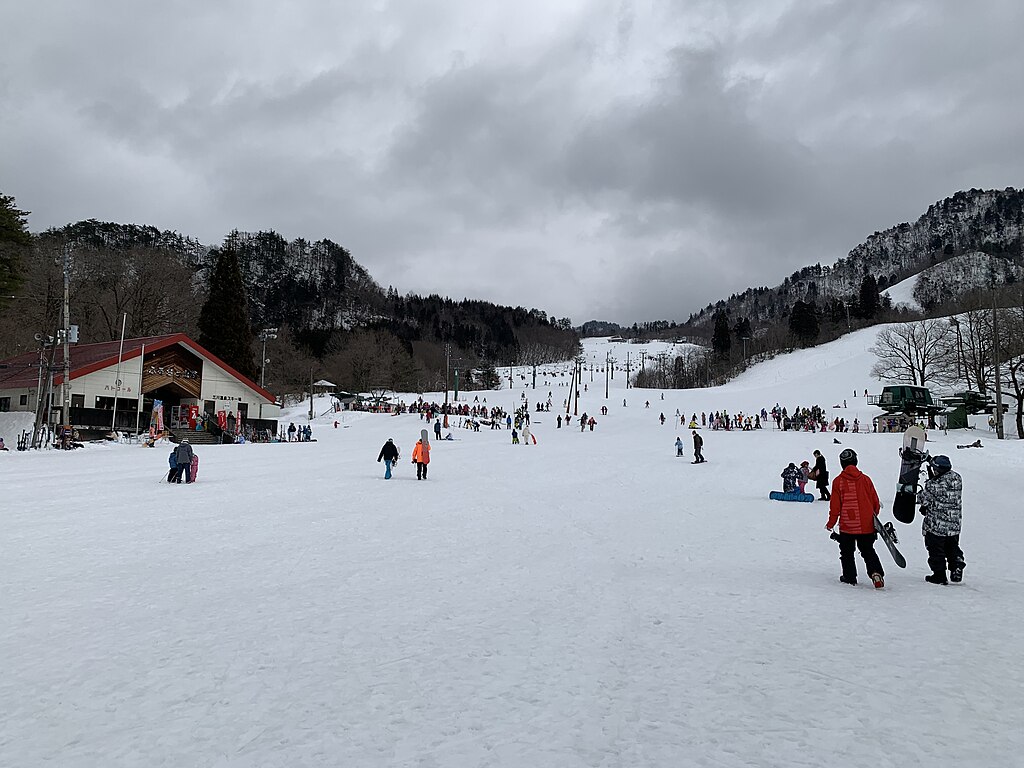 Mikawa Onsen in Japan - a group of people skiing down a snowy hill.
