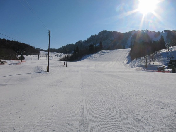 Winter scene at Mikawa Onsen in Japan with snow-covered terrain, a charming chalet in the background, popular for winter sports and skiing activities.