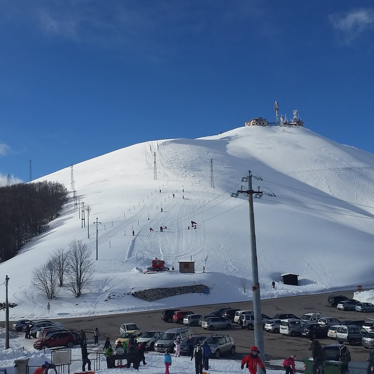 Forca Canapine in Italy - a group of people skiing down a snow covered mountain.
