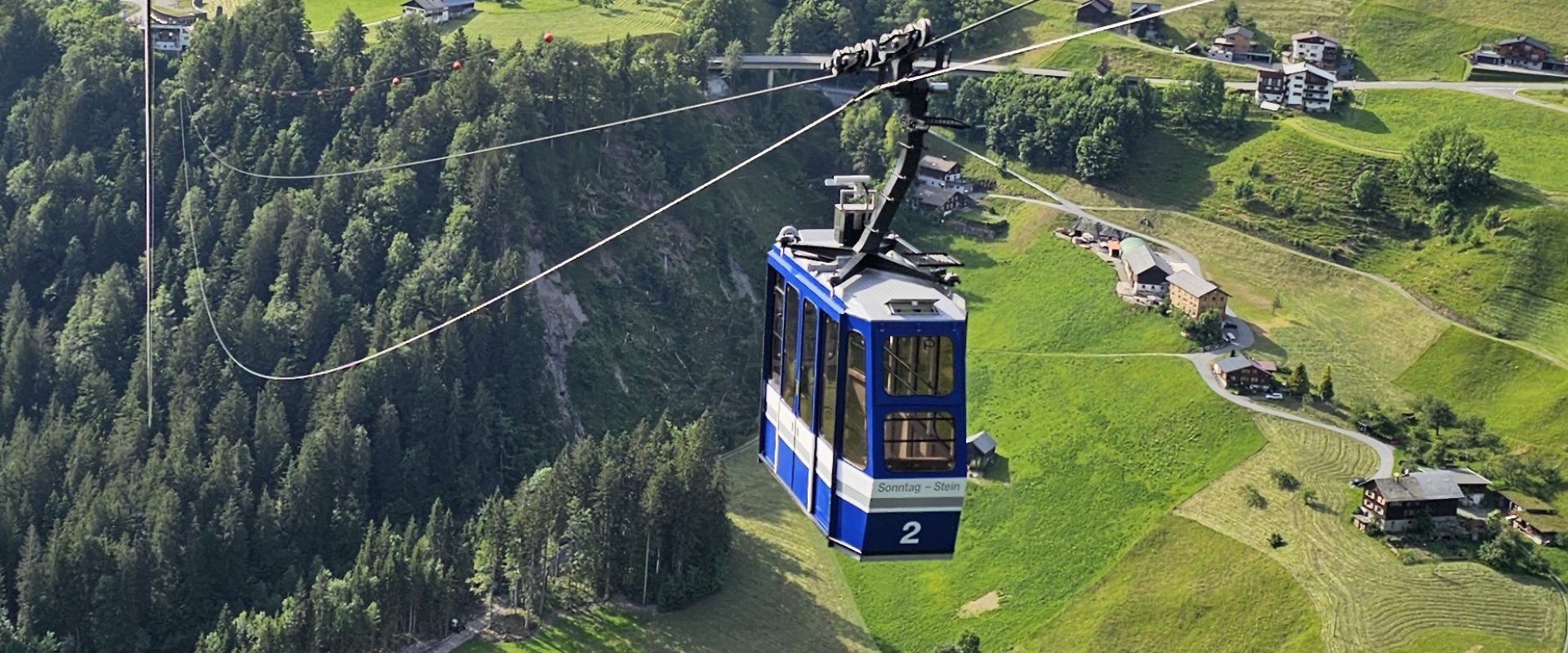 Seilbahnen Sonntag in Austria - a cable car going up the side of a mountain.