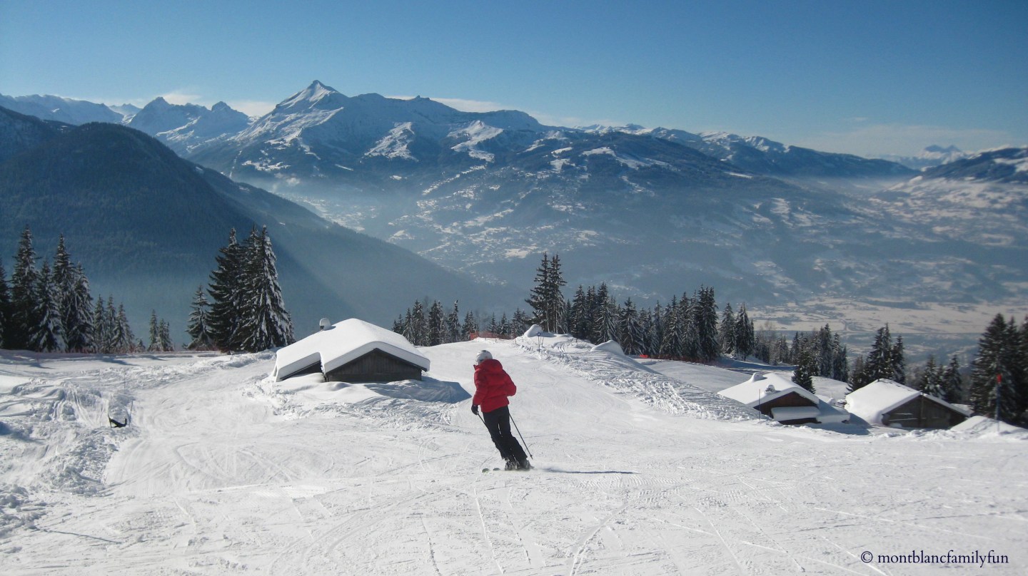 Winter sports enthusiasts enjoy a day in the snow at Passy Plaine-Joux ski resort in France, complete with skiers, a charming chalet, set amidst pristine white mountains.