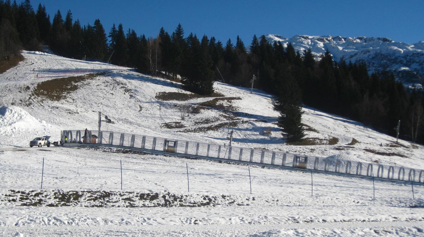 View of Passy Plaine-Joux in France, showcasing a bustling winter sports centre, a cosy challet, and dynamic ski scenes set against pristine, snow-covered slopes.