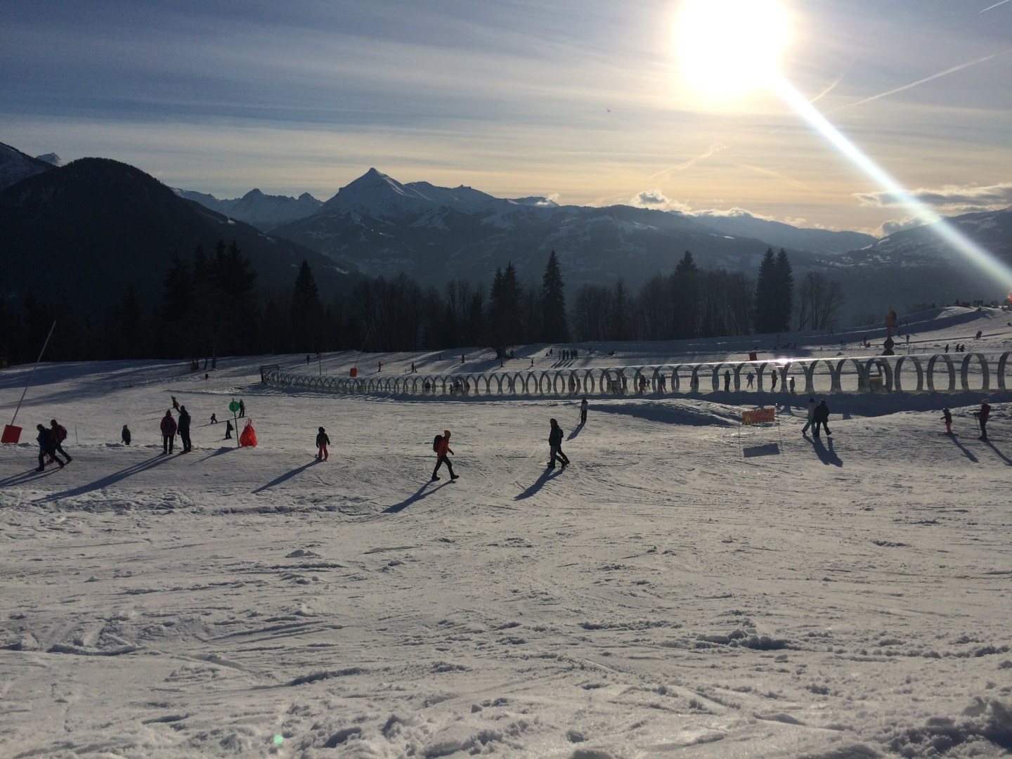 A winter sports scene at the scenic Passy Plaine-Joux ski resort in France featuring a charming chalet and enthused skiers enjoying the slopes.