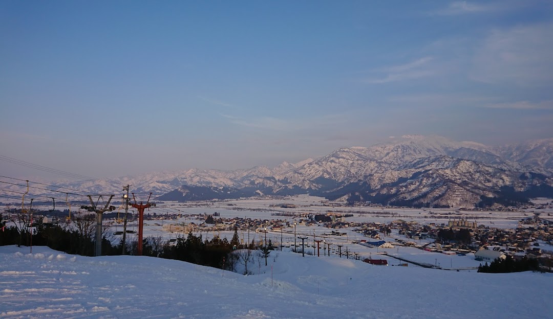 A breathtaking winter scene in Itsukamachi, Japan, featuring a stunning snowy landscape. A charming chalet nestled amongst powdery snow highlights a popular ski resort.