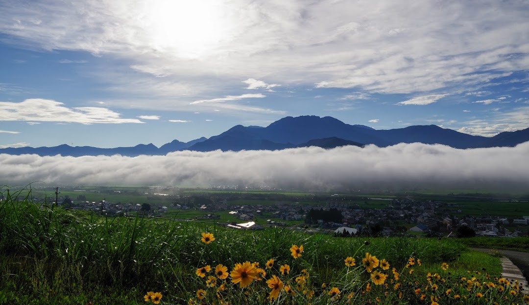 Challet nestled at the base of a mountain in Itsukamachi, Minamiuonuma, Niigata, Japan with a mountain bike in the foreground. The sunny winter day accentuates the stunning scenery.