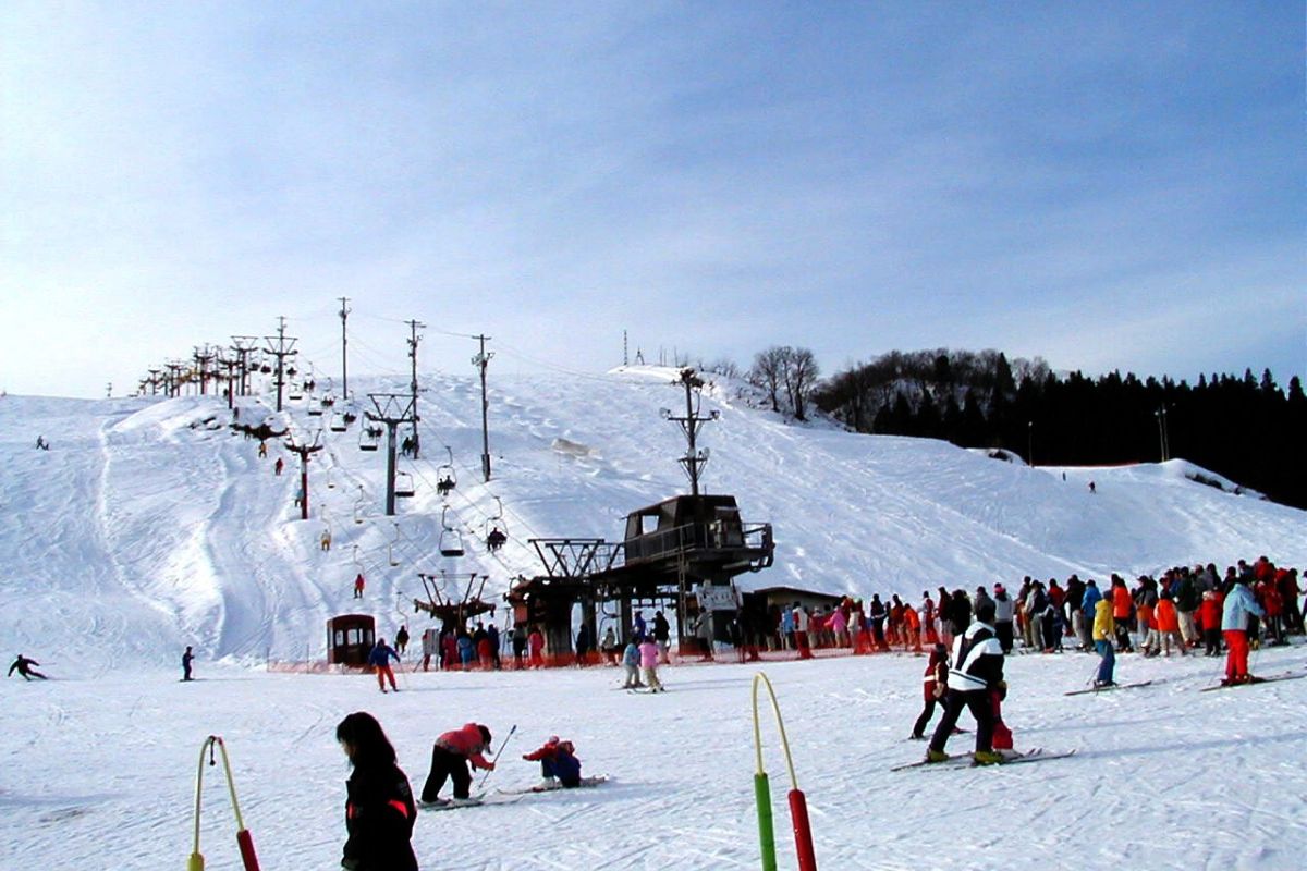Itsukamachi in Japan - a group of people skiing down a snowy hill.