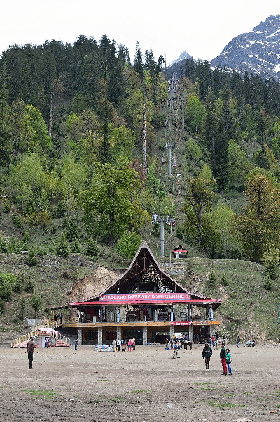 Solang Ropeway & Ski Center in India - a group of people standing in front of a train station.