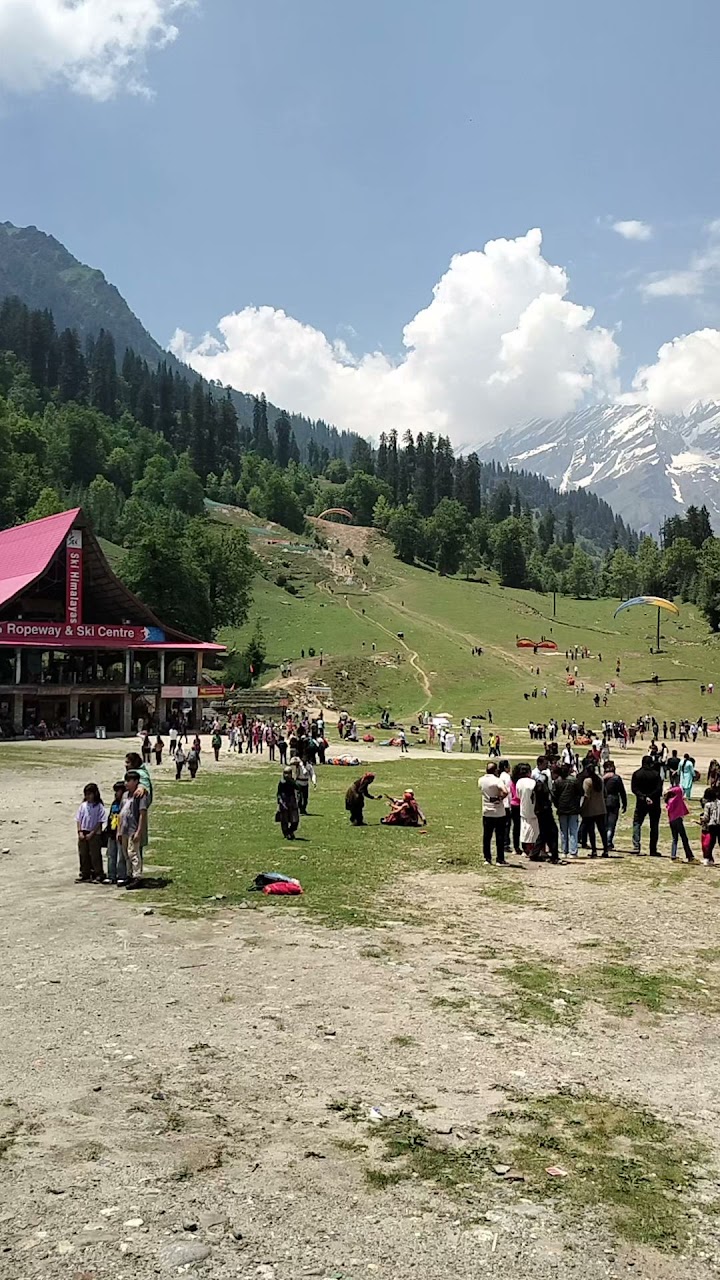 Solang Ropeway & Ski Center in India - a group of people standing in a field.