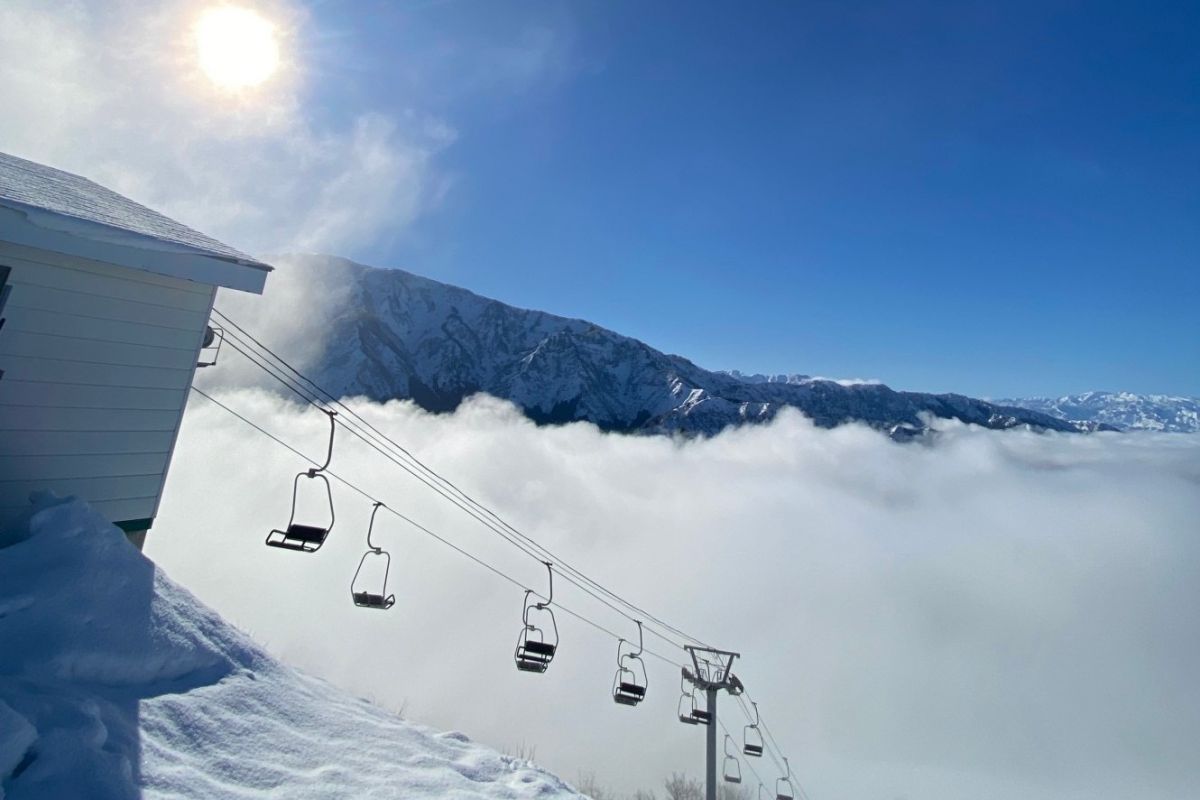 Hakkai Sanroku Ski Area in Japan - a ski lift going up a snowy mountain.
