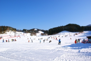 A winter sports scene at Taiheizan Opas in Tōhoku, Japan, featuring a bustling winter sports centre and a ski resort, surrounded by a breathtaking winter scenery.