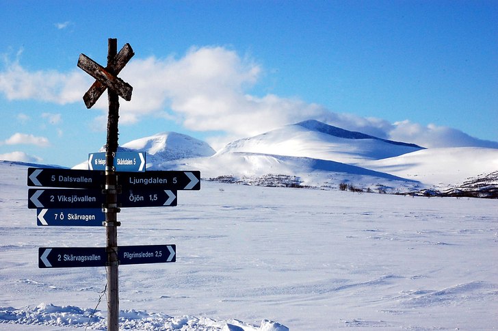 Winter scene at Ljungdalsbergets Turist AB in Northern Sweden showcasing a bustling ski resort amidst beautiful winter scenery, including a charming chalet, and a ski lift.