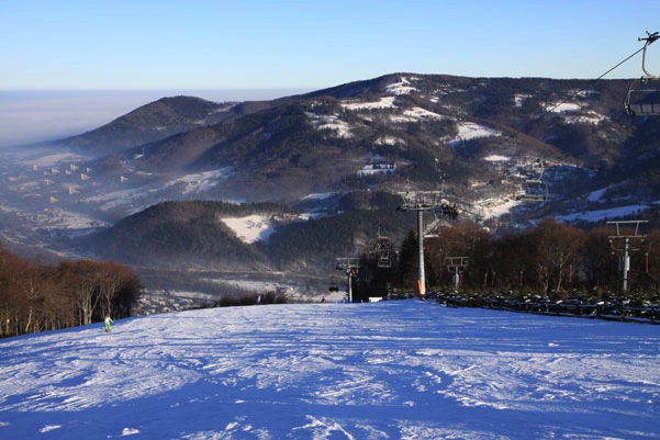 A scenic winter view at the Czantoria Rope in Ustroń Silesia Poland showcasing a bustling ski resort vibrant chalet and winter sports activity amid serene snow-covered landscapes.