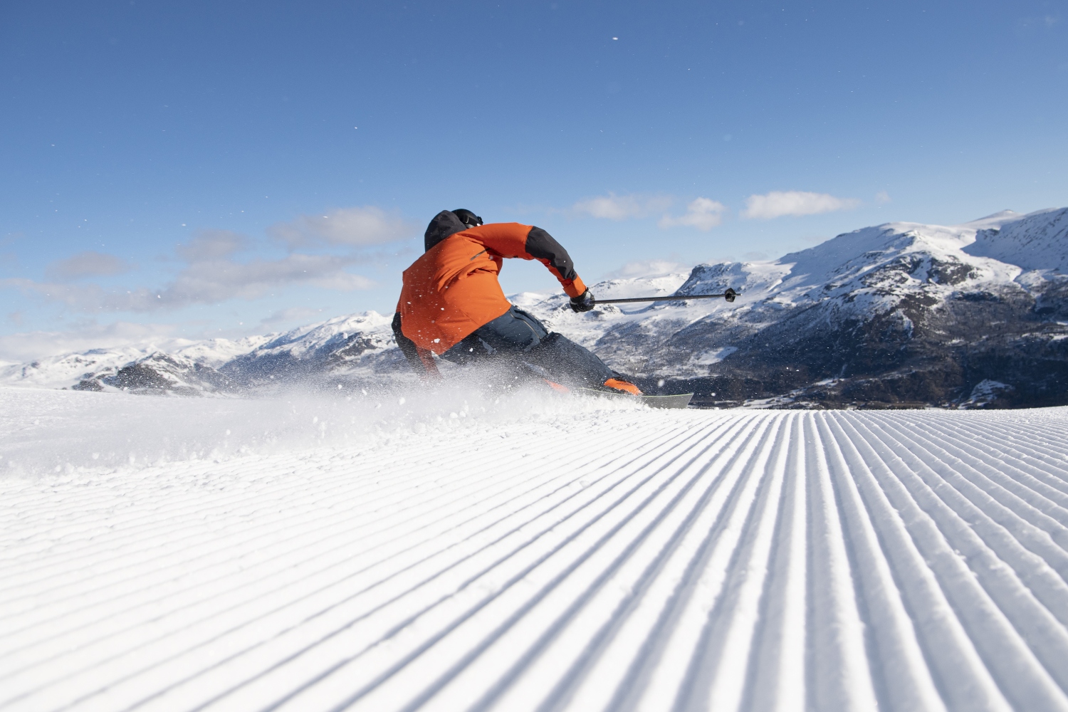 Hemsedal in Norway - a man in an orange jacket skiing down a slope.