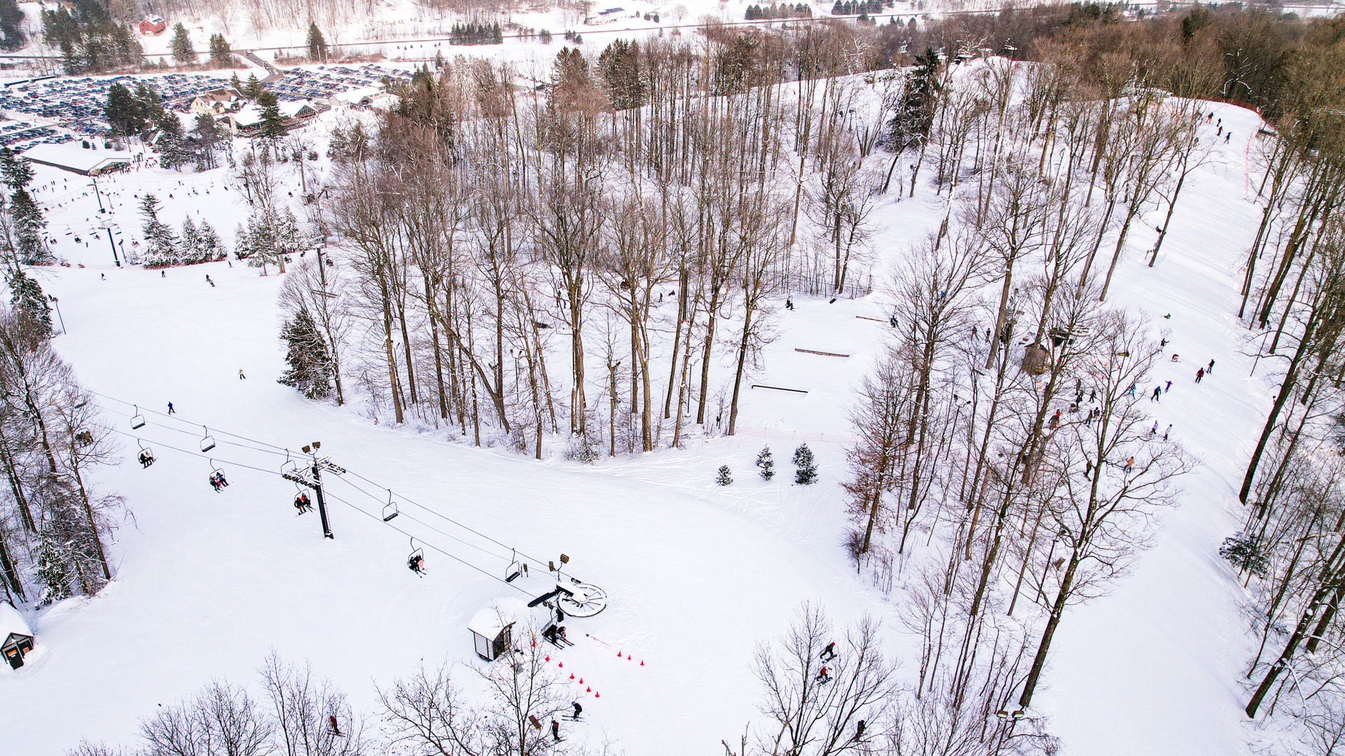 A picturesque view of Snow Trails, a popular winter sports centre in Mansfield, Ohio, featuring a stunning winter scene. Skiers and snowboarders can be seen dotting the snowy landscape, enjoying the ski resort facilities amidst a serene winter backdrop.