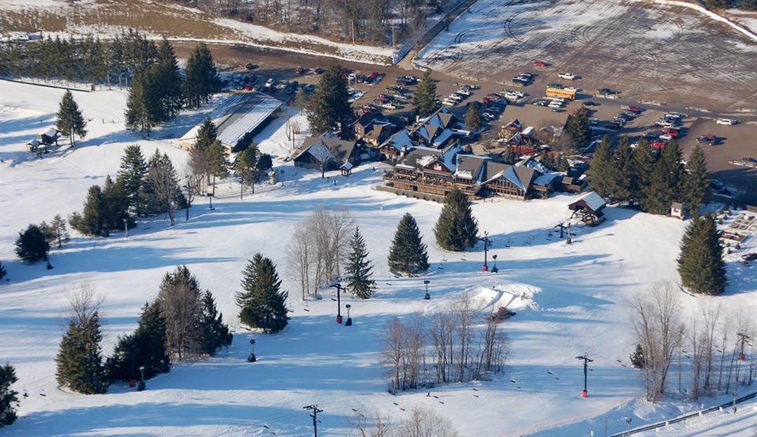 A bustling ski resort in Snow Trails Mansfield Ohio with skiers enjoying the frosty slopes. A ski lift looms in the background transporting eager skiers to the summit.