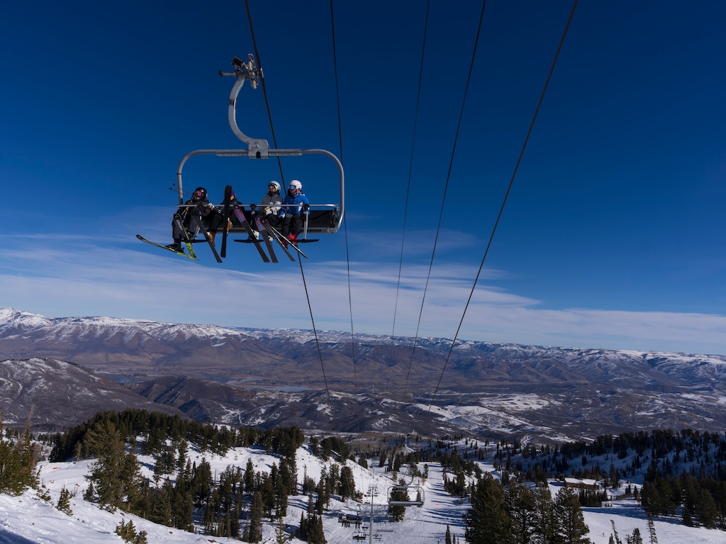 Snowbasin in USA - two people riding a ski lift in the air.