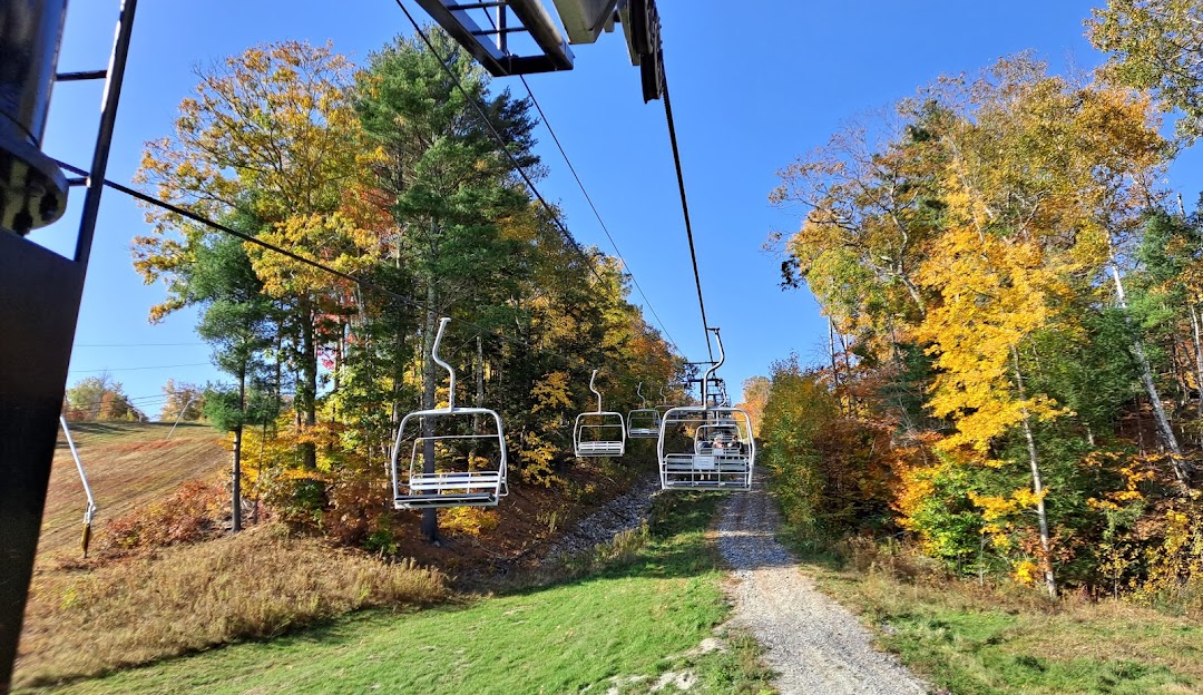 A picturesque view at Camden Snow Bowl in Maine USA featuring a ski lift ascending amongst a wintery landscape. The vibrant ski resort is a popular destination for winter sports enthusiasts.