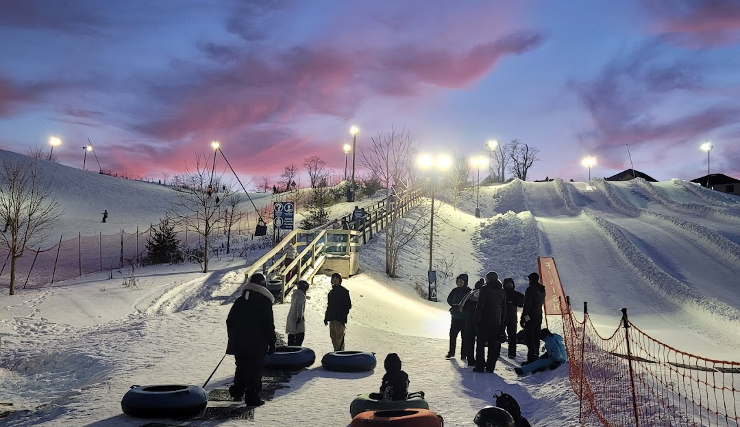 A lively image of Boler Mountain ski resort in London Ontario Canada. The scene captures a bustling winter sports scene with skiers enjoying their time on the slopes amidst a beautiful snow-clad landscape.