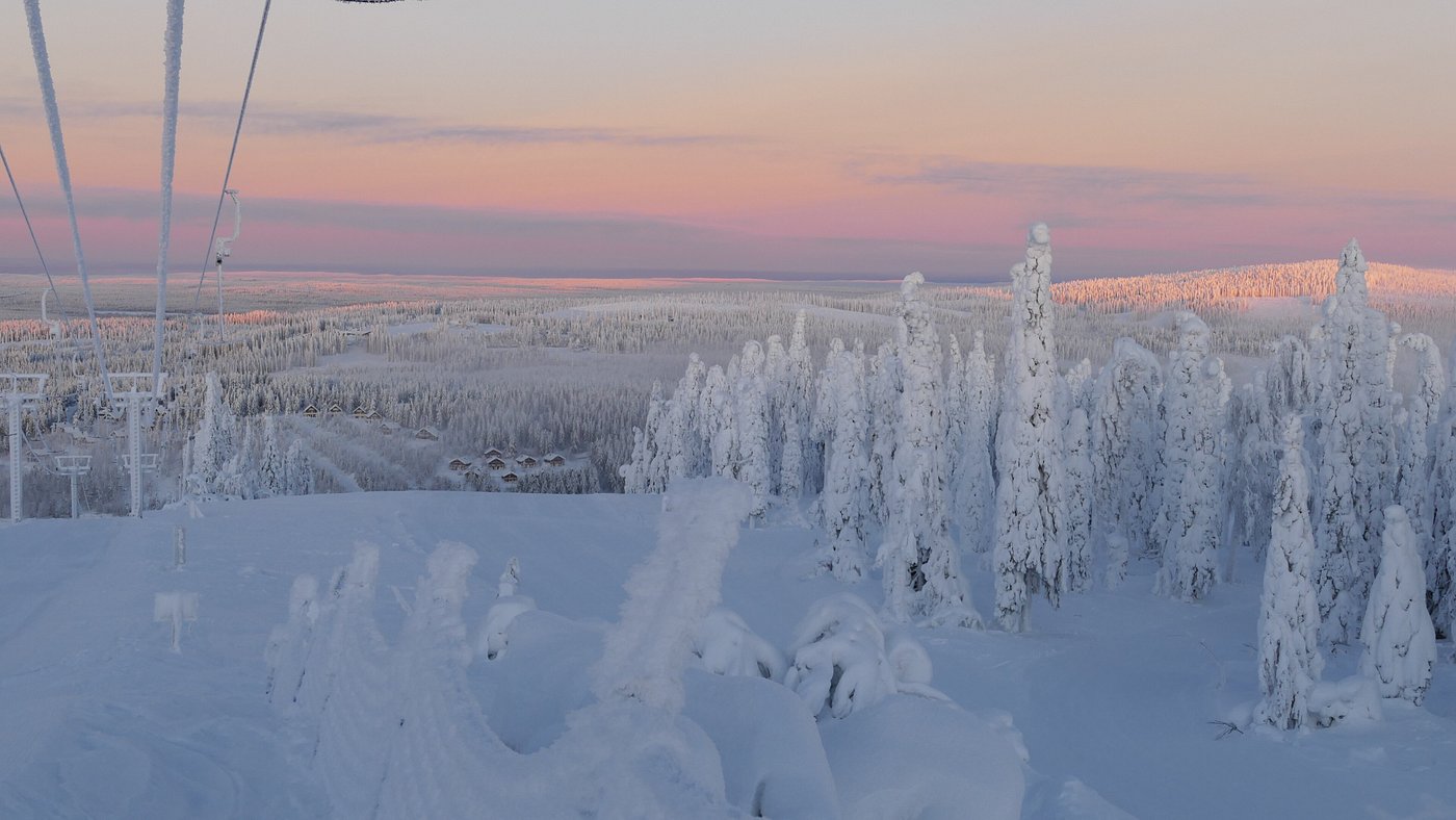 Winter scene at Ukkohalla in Kainuu, Hyrynsalmi, East Finland featuring a ski resort and a chalet amidst the stunning snow-covered landscape.