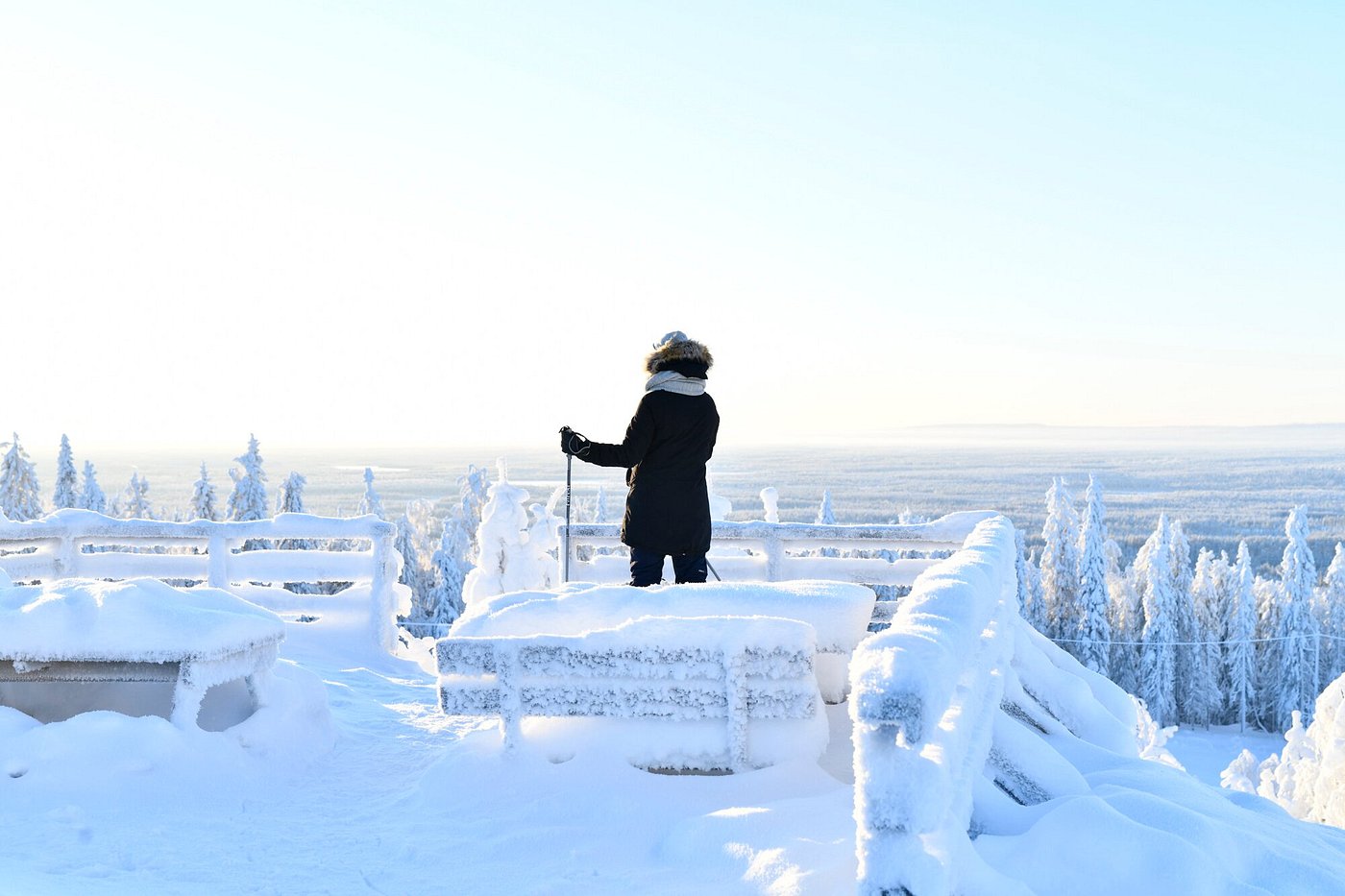 Stunning winter landscape at Ukkohalla in East Finland, showcasing a beautiful white snowy cover, winter sports activities, and a chalet under a bright, sunny sky.
