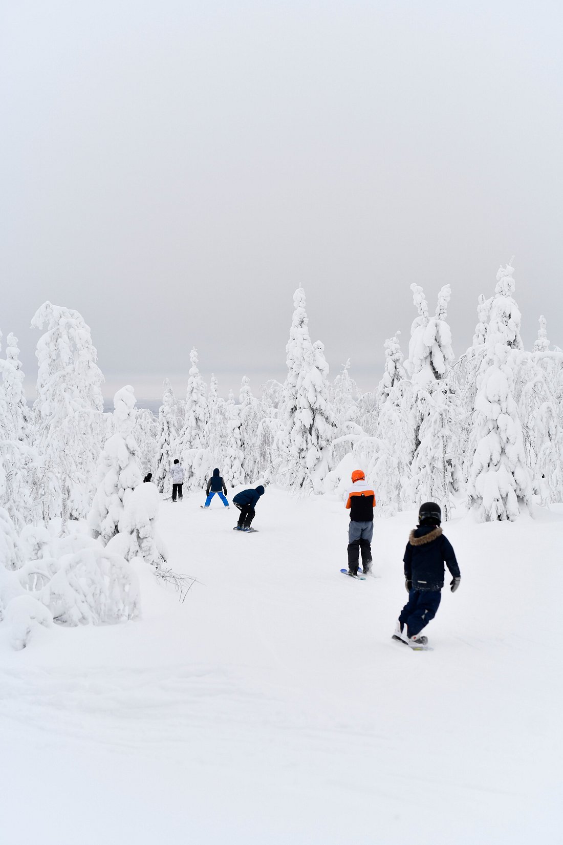 Winter sports enthusiasts enjoying a day of skiing at Ukkohalla ski resort in Kainuu, East Finland, against a stunning, snowy landscape.
