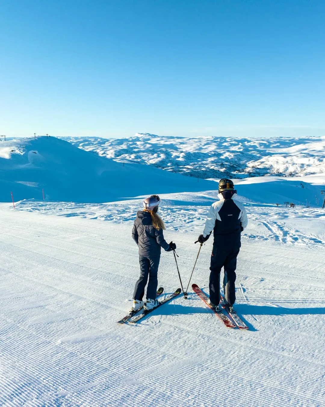 Haukelifjell Skisenter in Norway - two people standing on top of a snow covered mountain.