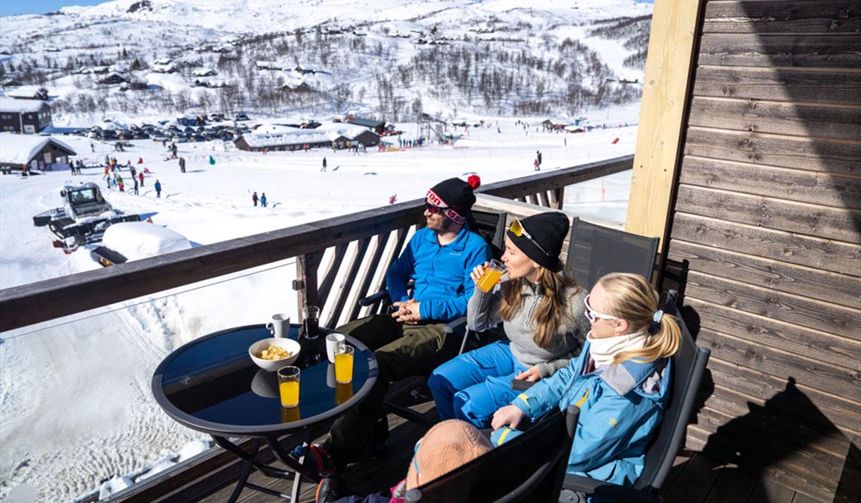 Haukelifjell Skisenter in Norway - two people sitting at a table in front of a mountain.