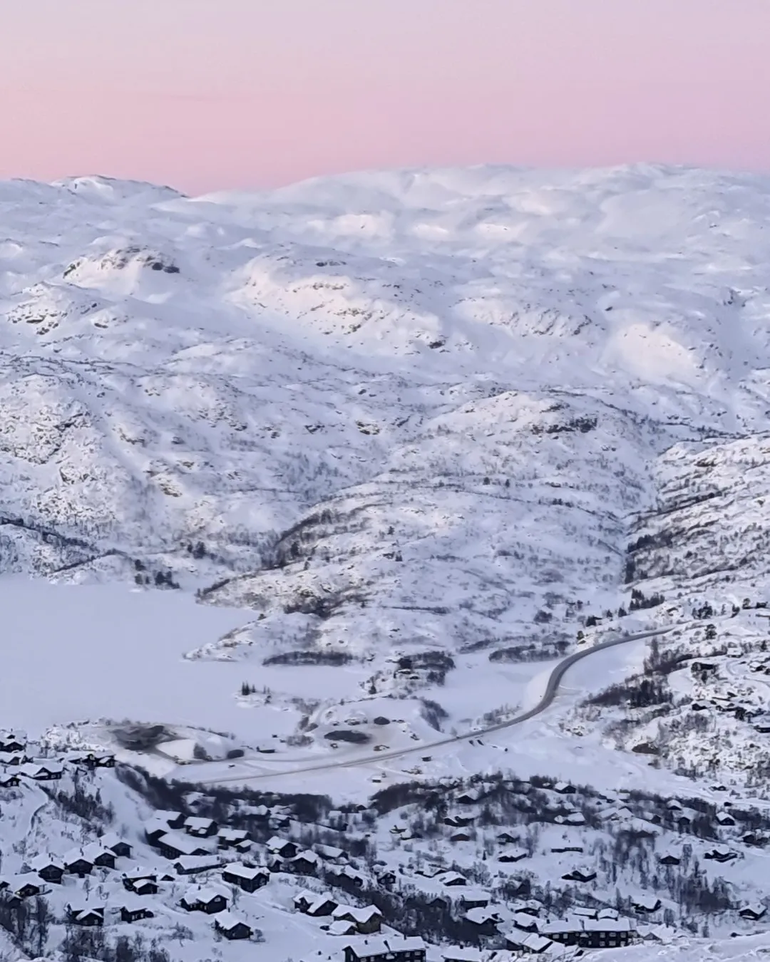 Haukelifjell Skisenter in Norway - a view of snow covered mountains and a pink sky.