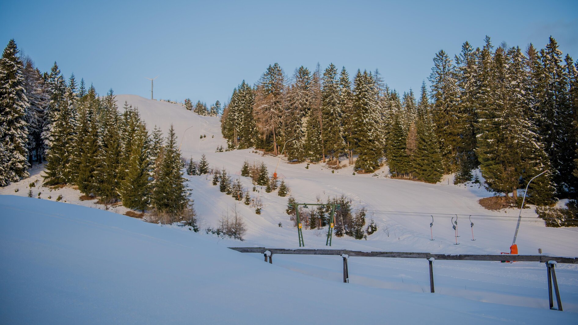 Rieseralm in Austria - a snow covered ski slope with trees in the background.