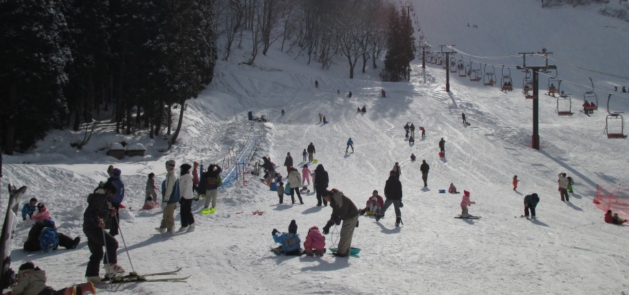 A vibrant winter sports scene at a ski resort in Taira Japan featuring a chalet and a ski lift amidst a snow-covered landscape.