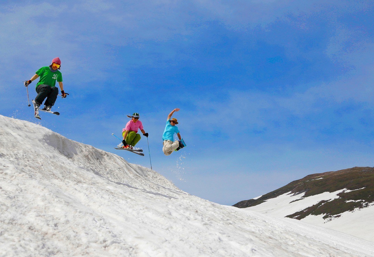 Gassan in Japan - two snowboarders jumping off of a snowy hill.