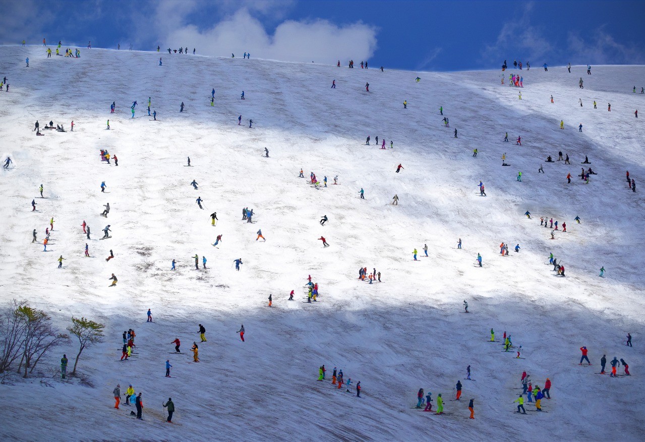 Gassan in Japan - a large group of people walking up a snowy hill.