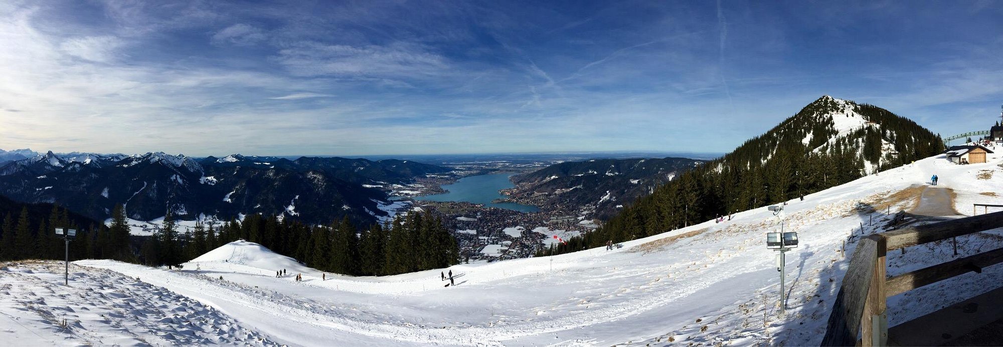 A sunny day at Wallberg ski resort in Bavaria Germany showcasing winter sports scene with a ski lift in operation and a quaint chalet nestled in the backdrop.