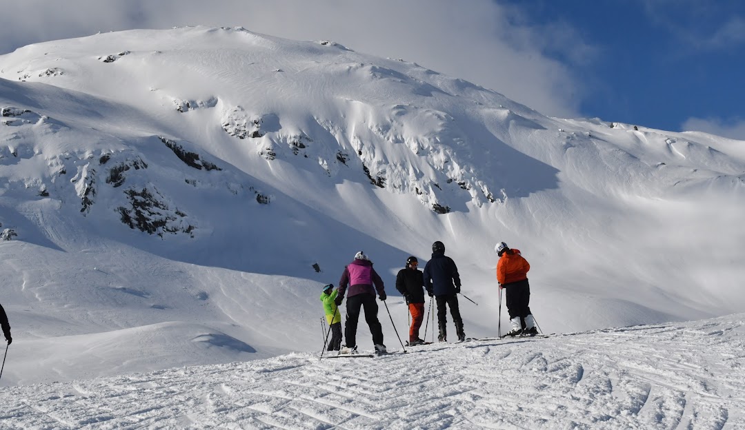 Winter scene at Sauda Skisenter, Western Norway, showcasing people enjoying skiing, a welcoming chalet in the background, and snowy mountain slopes of the ski resort.