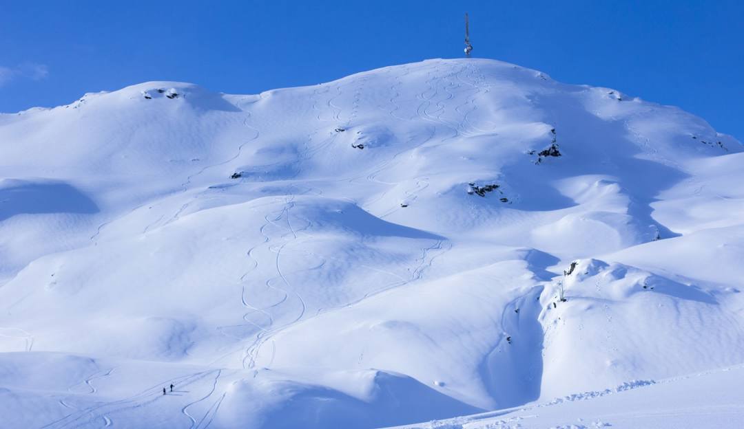 A skier glides down a pristine snow-covered slope at Sauda Skisenter in Western Norway a challet nestled against the picturesque ski resort landscape.