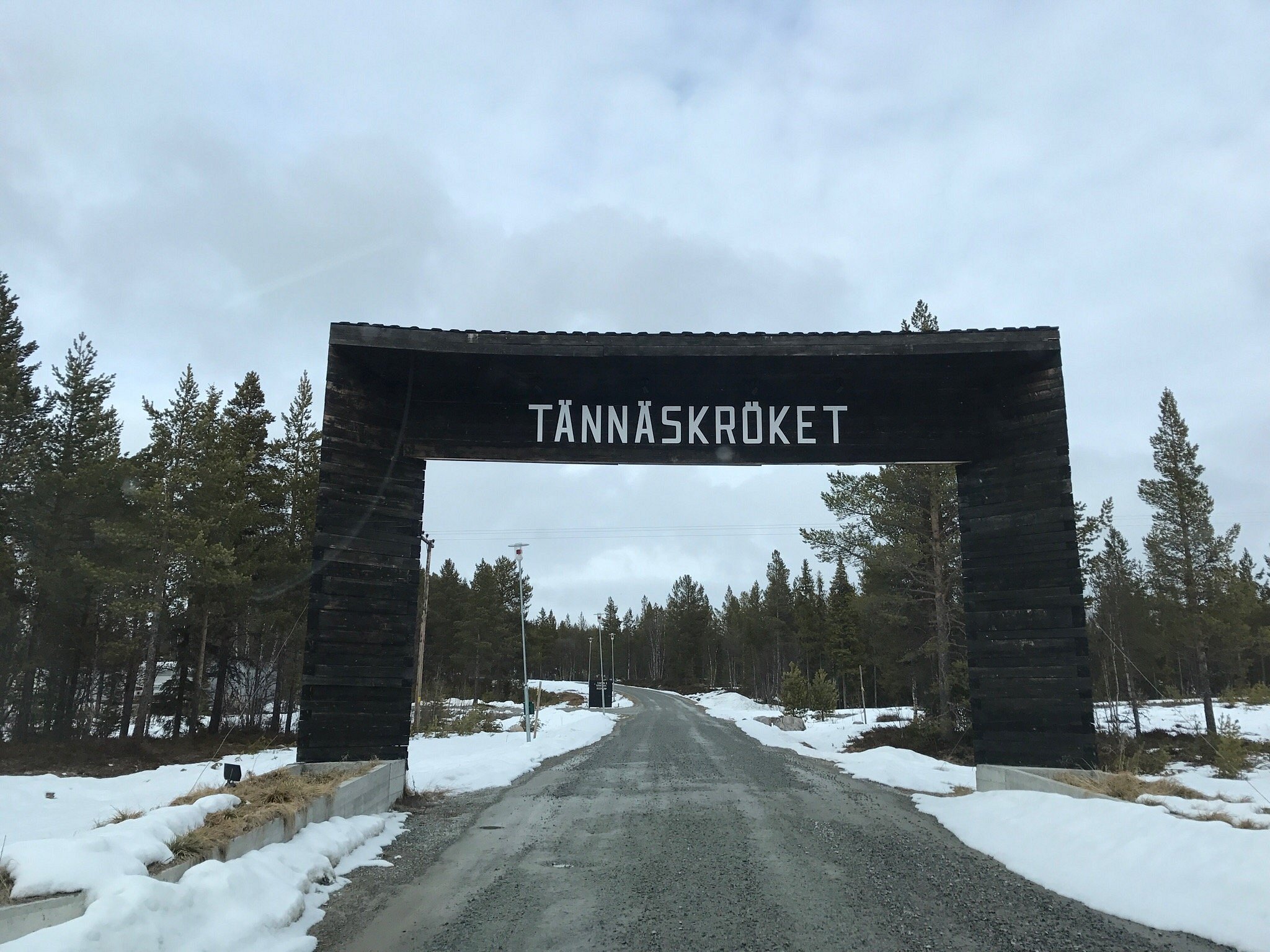 A stunning winter panorama at the Tännäskröket ski resort in Northern Sweden, showcasing a lively winter sports scene with a snowmobile in the foreground.