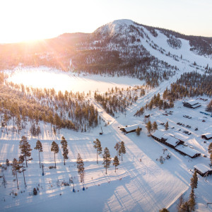 A bustling winter sports scene at Tännäskröket ski resort in Northern Sweden showcasing stunning winter scenery with skiers enjoying the pristine slopes amidst the serene snow-capped Funäsfjällen mountains.