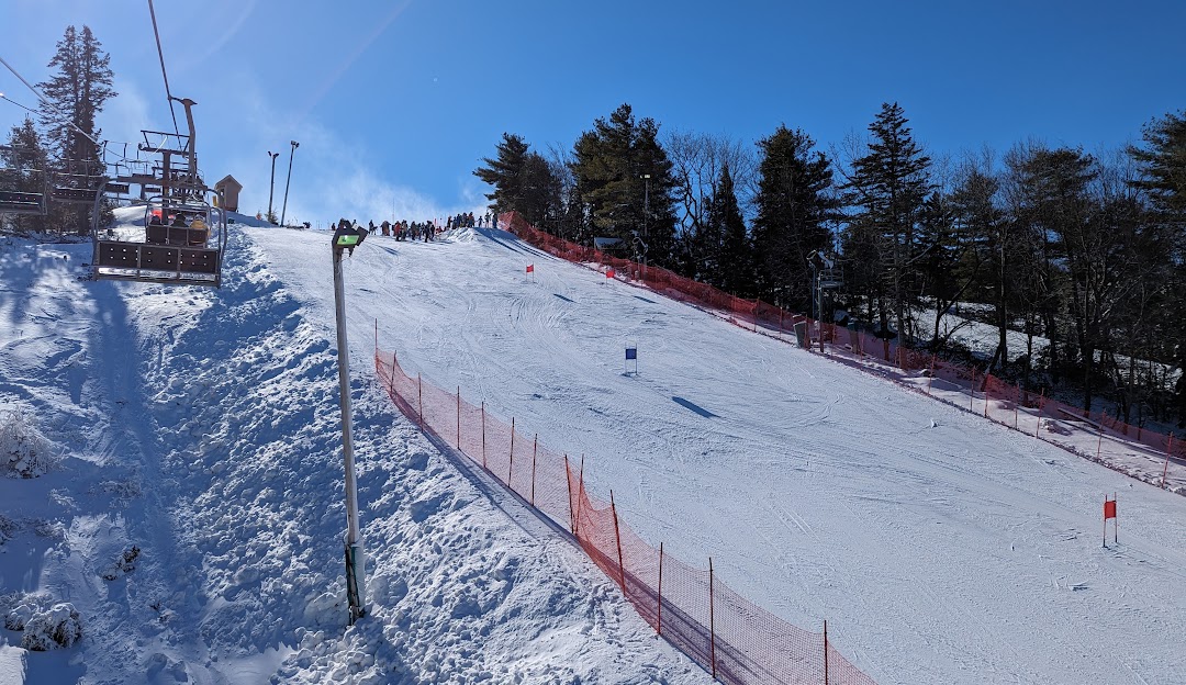 A lively scene at Big Boulder a popular winter sports spot in Lake Harmony Pennsylvania showcasing skiers in action and a welcoming chalet amidst the snowy ski resort.