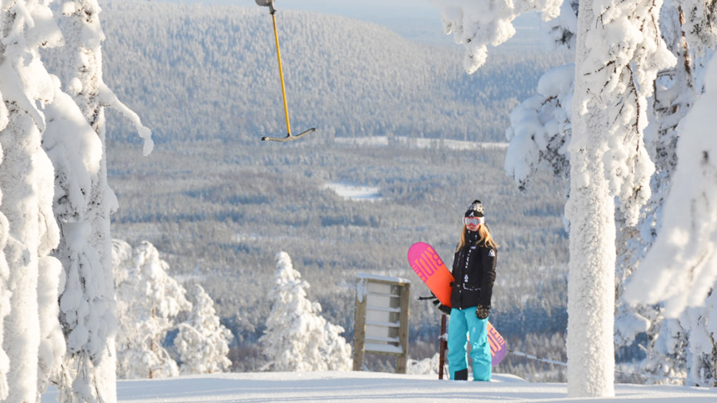 Suomutunturi in Finland - a person standing in the snow with a snowboard.