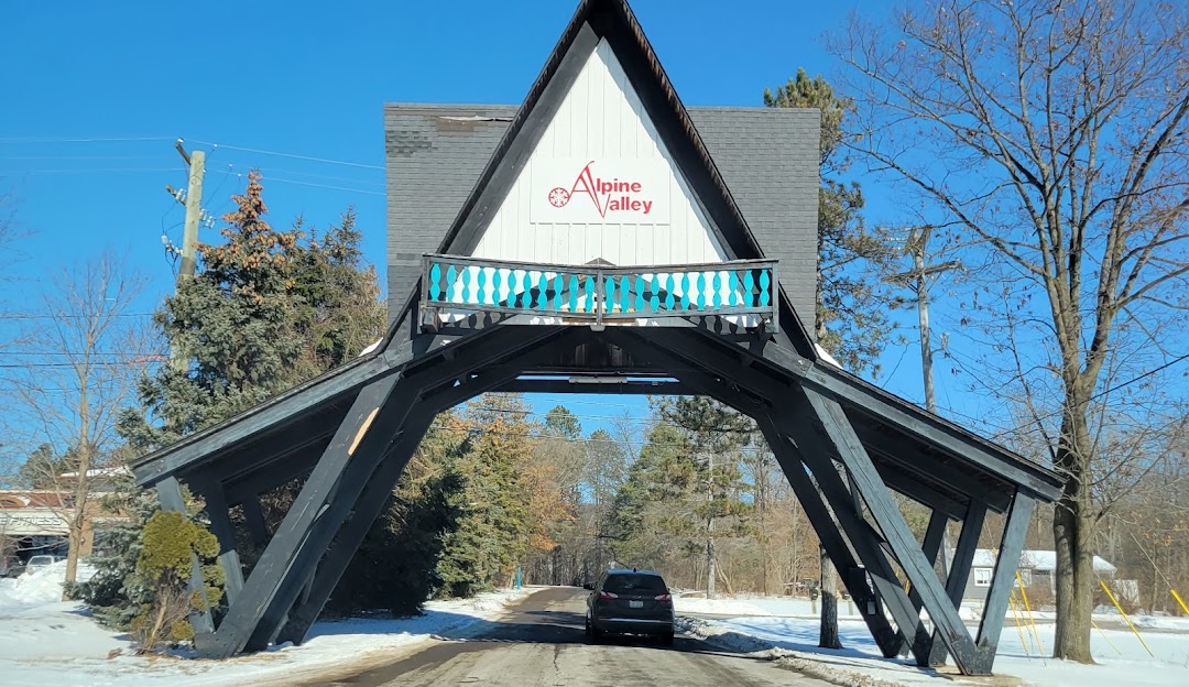 Picture of Alpine Valley in White Lake, Michigan showcasing a prominent lodge set against the backdrop of a picturesque mountain. The scene indicates a bustling ski resort and winter sports centre.