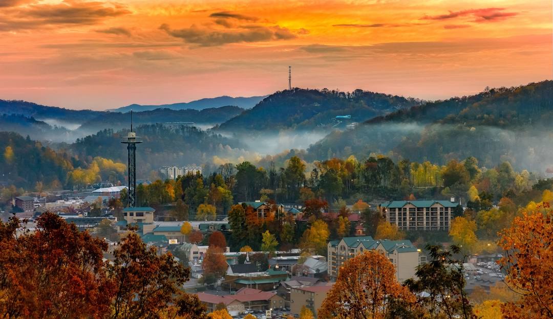 A scenic view of Ober Mountain in Gatlinburg, Tennessee, highlighting a mountain, a chalet, a bustling ski resort amid a striking winter landscape perfect for winter sports.
